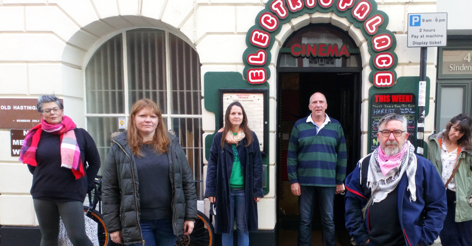 six people looking concerned outside the cinema